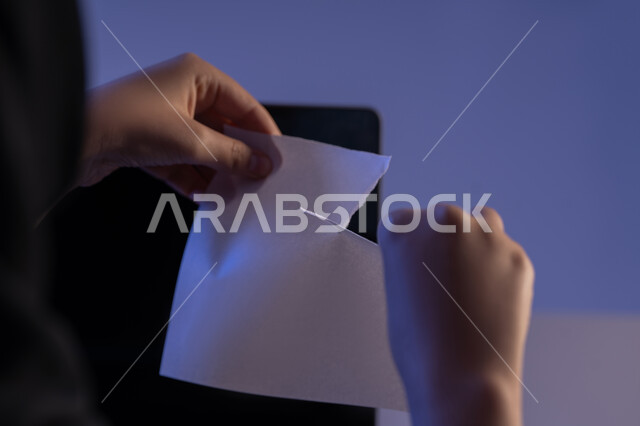 كسر القواعد المهنية في الشركات، عدم الموافقة على شيء ما، صورة مقربة من الخلف لامراة عربية خليجية اماراتية تقوم بتمزيق ورقة بيضاء فارغة، شابة سعودية تعقد صفقة غير ناجحة، مهن ووظائف إدارية مكتبية