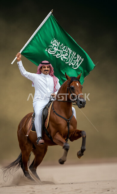 الاحتفال بالأعياد والمناسبات الوطنية, استذكار اليوم الوطني السعودي 23 سبتمبر, ذكرى يوم العلم 11 مارس, رجل عربي خليجي سعودي يرتدي الثوب التقليدي والشماغ يمتطي حصان بني ويرفع بيده علم المملكة العربية السعودية, مفهوم الاعتزاز والفخر بالوطن, خلفية بنية