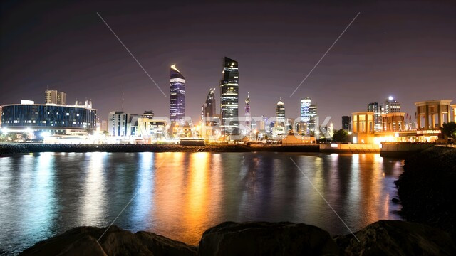 الفن الهندسي المعماري الحديث للمنشآت والمباني السكنية والتجارية, الواجهة البحرية على ساحل الخليج العربي, التطور والتقدم العمراني على الطراز العصري في دولة الكويت, الأبراج وناطحات السحاب المطلة على الشاطئ في الليل، مناطق جذب السياح من شتى أنحاء العالم