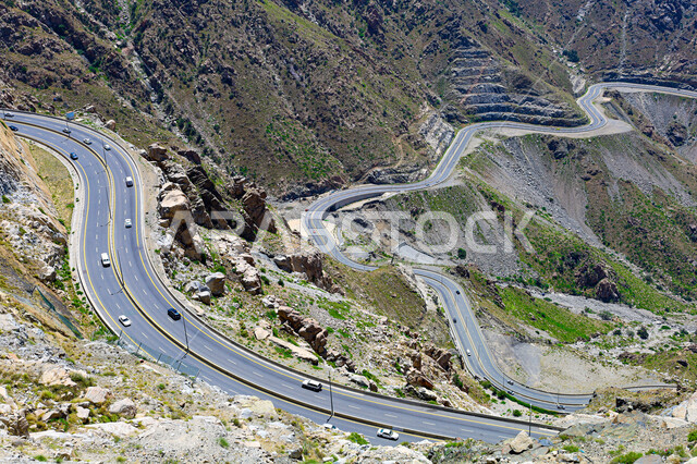  طريق اسفلتي ملتوي وعر وسط الجبال الصخرية في منطقة عقبة الهدا، الطبيعة والبيئة الجبلية والقمم والمرتفعات في المملكة العربية السعودية، حركة مرور وسير السيارات على الجبال في مدينة الطائف