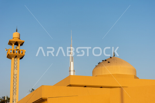 Dome of a mosque in the Jumeirah area overlooking the Burj Khalifa during the day in Dubai, the architectural art of building towers and skyscrapers, famous landmarks and places in the United Arab Emirates, the call of Muslims to perform religious duties and prayers