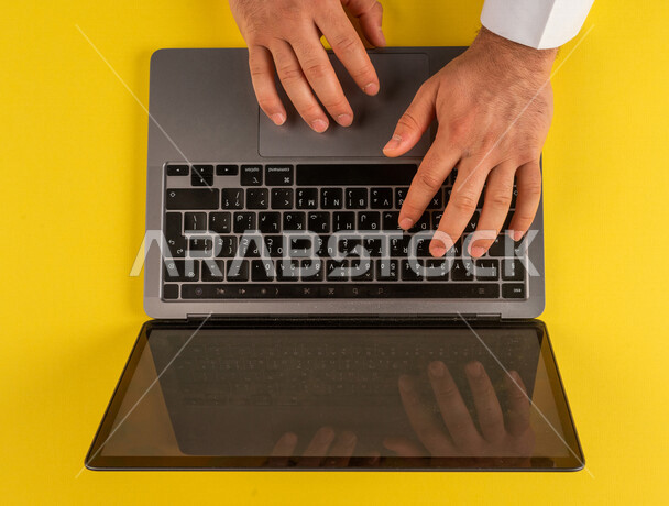 صورة مقربة ليد رجل عربي خليجي سعودي يستخدم الحاسوب المحمول ،مدخل بيانات، الكتابة من خلال لوحة المفاتيح ، التسويق والترويج للمواقع الالكترونية، التعليم عن بعد ، استخدام الاجهزة التقنية الحديثة في الاعمال الادارية