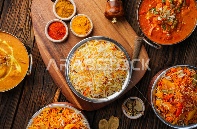 Food presentation arts in oriental restaurants, a plate of delicious biryani rice with pieces of chicken decorated with parsley on a wooden base, popular Gulf Saudi Arabian dishes, traditional foods and dishes, delicious healthy food recipes
