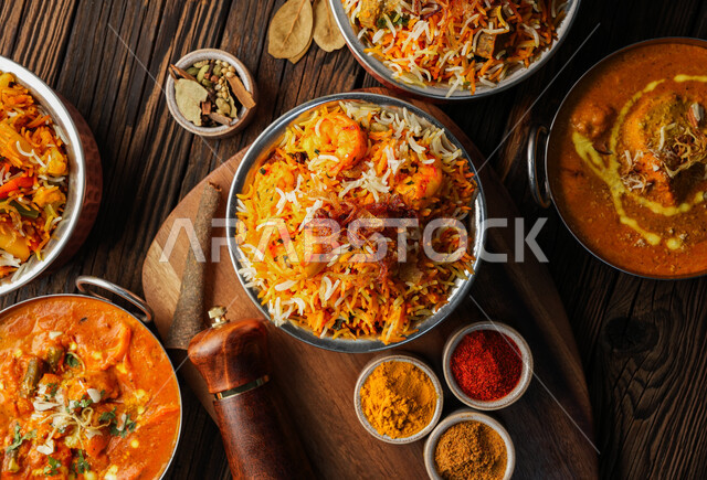 فنون تقديم الطعام في المطاعم الشرقية، طبق من أرز البرياني اللذيذ مع قطع الدجاج على قاعدة خشبية, أكلات شعبية عربية خليجية سعودية، مأكولات وأطباق تقليدية، وصفات طعام لذيذة صحية