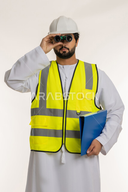 Expanding field of vision, supervising engineering projects, engineering sector in UAE, close-up portrait of an Arab Gulf Emirati engineer wearing a kandura, helmet and protective vest looking through binoculars holding a work file in his hand, planning and researching for the future, white background