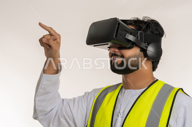 Interacting with virtual engineering, close-up side portrait of an Arab Gulf Emirati engineer wearing a kandura, work jacket and virtual reality glasses raising index finger to touch holographic elements, future vision 2030, integrating technology with engineering fields, white background