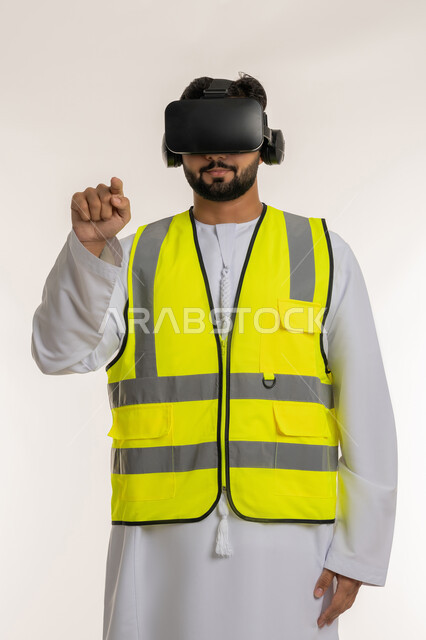 الاندماج مع الهندسة الافتراضية، بورتريه لمهندس عربي خليجي إماراتي يرتدي الكندورة والسترة الخاصة بالعمل ونظارة الواقع الافتراضي يرفع إصبع السبابة للمس عناصر هولوجرامية، دمج التكنولوجيا بالمجالات الهندسية، رؤية مستقبلية 2030، خلفية بيضاء