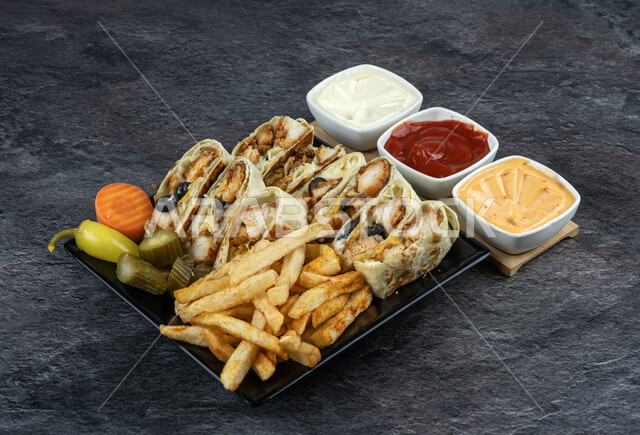 ساندوتش شاورما الدجاج اللذيذ في طبق اسود، وجبات الطعام السريعة الشهية، المطاعم العربية في المملكة العربية السعودية، وصفات الأكل اللذيذة، المأكولات الشهية مع الخضراوات والصلصات