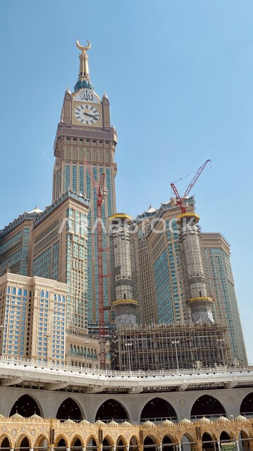 Makkah Royal Clock Tower during the day, performing Hajj and Umrah rituals, sacred Islamic religious places and landmarks, architectural engineering art of towers and skyscrapers, urban growth and progress of facilities and buildings in the Kingdom of Saudi Arabia, worship and closeness to God