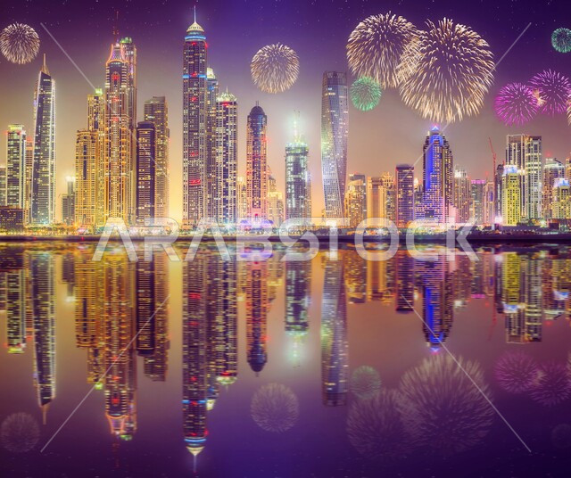 منظر الأضواء والألعاب النارية في سماء مدينة دبي، إنعكاس الأبراج وناطحات السحاب المضيئة ليلاً على مياه البحر، الفن الهندسي المعماري للمباني والمنشآت في الإمارات العربية المتحدة، الإحتفال في الأعياد والمناسبات الوطنية الاماراتية