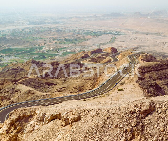 حركة مرور السيارات على الطرقات والشوارع الاسفلتية المعبدة في المناطق الجبلية المرتفعة، جبل حفيت في الامارات العربية المتحدة،  التكوينات والتشكيلات الصخرية في الاماكن السياحية المشهورة