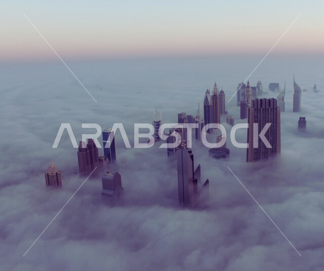 View of towering skyscrapers and towering buildings above the clouds, urban growth and progress in the United Arab Emirates, modern architectural art, landmarks and famous places