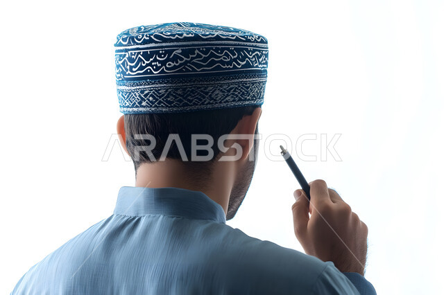 الإستعداد للكتابة وتحديد شيء ما, تدوين وتسجيل الملاحظات، بورتريه مقرب من الخلف لشاب عربي خليجي عماني يرتدي الدشداشة والكمه يمسك بيده قلم يكتب شيء ما, مفهوم التعليم بالمناهج المقررة، خلفية بيضاء