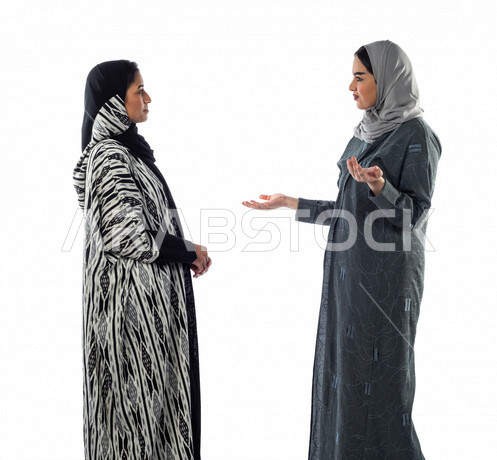 Portrait of two Gulf Arab women standing together, discussing work-related matters, a Saudi Arabian Gulf team, achieving work goals
