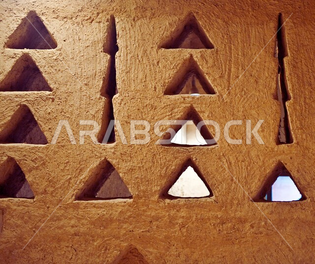 مباني شعبيه تراثيه قديمه  في الدرعيه القديمة بمدينة الرياض ، صورة مقربه لنوافذ باشكال هندسيه على جدار طيني ، الفن الهندسي المعماري القديم في المملكة العربية السعودية