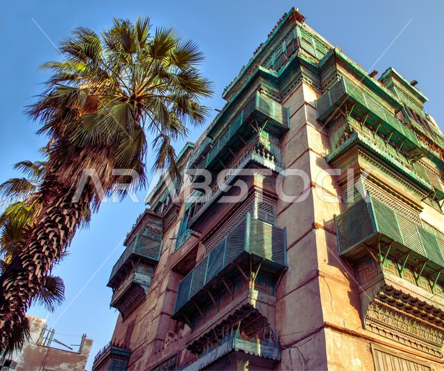 التصميم المعماري على الطراز العربي القديم، منظر السماء الزرقاء فوق المباني الأثرية في البلد التاريخي في جدة, المدينة التاريخية في المملكة العربية السعودية، أماكن سياحية تراثية شعبية، المعالم التاريخية في حي البلد، الاهتمام بزراعة أشجار النخيل