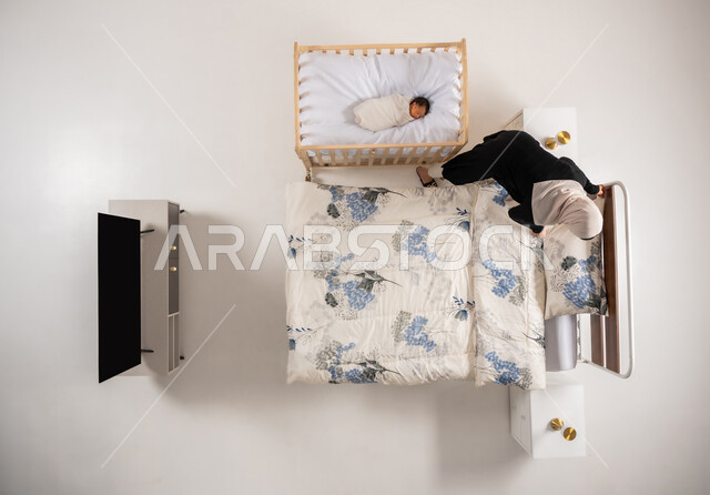 اداء الواجبات وتنظيم المنزل، مفهوم الاسرة وتحمل المسؤولية، العناية بالاطفال حديثي الولاده، دور الأهل في حياه الأبناء، امرأة سعودية تقوم بانجاز المهام المنزلية، بورتريه علوي عامودي لام عربيه خليجيه عمانية ترتيب سريرها، خلفيه بيضاء