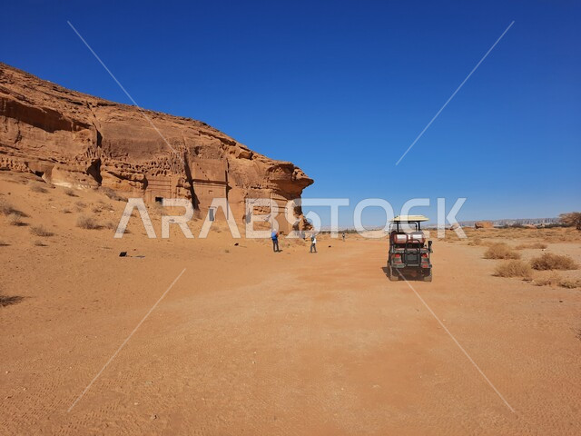 الأماكن السياحية في المناطق الصحراوية، التشكيلات و التكوينات الصخرية في العلا وسط صحاري المملكة العربية السعودية، سيارة جولف كهربائية امام المعالم التاريخية القديمة في مدائن صالح، الكهوف التراثية في موقع الحجر الأثري في الصحراء