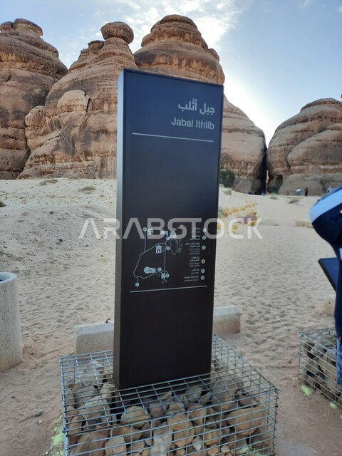 التشكيلات و التكوينات الصخرية في العلا وسط صحاري المملكة العربية السعودية، المعالم التاريخية القديمة في مدائن صالح، الأماكن السياحية في المناطق الصحراوية، لافتة معدنية زرقاء لجبال الاثلب في الصحراء