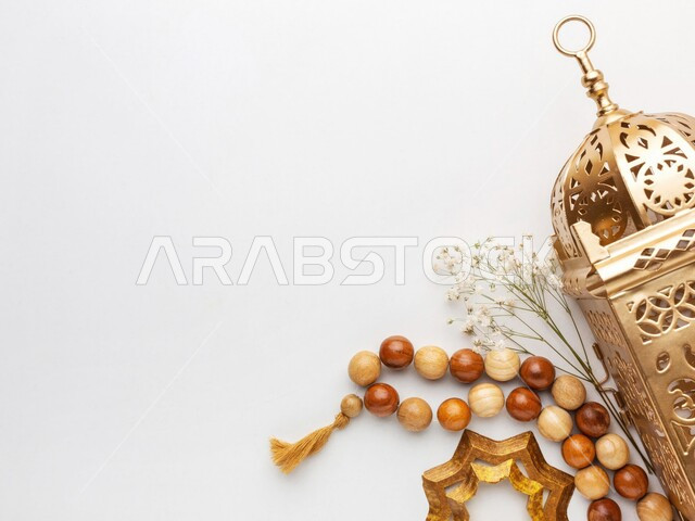 زينة وديكورات الاعياد والمناسبات الدينية، فوانيس وتحف تقليدية للاحتفال بقدوم شهر رمضان المبارك، أجواء رمضانية وروحانية إسلامية، فانوس عربي معدني مزخرف بجانب سبحة، خلفية بيضاء