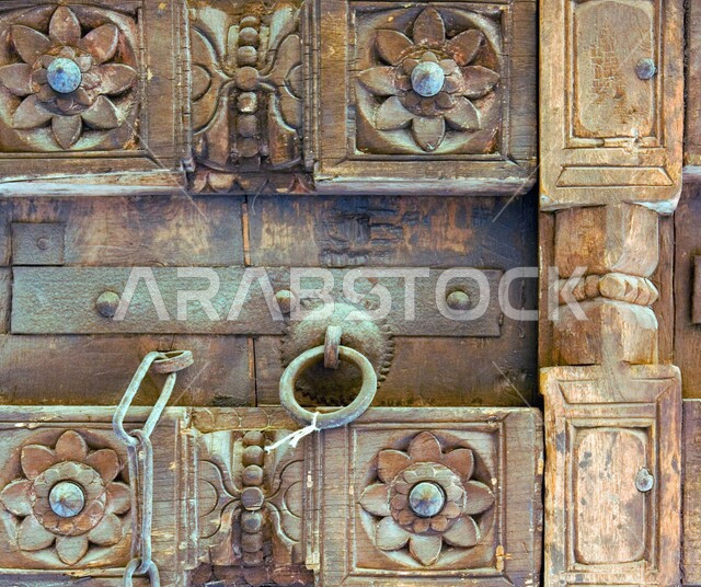 النحت والرسومات على باب خشبي بتصميم معماري عربي قديم، البيوت الأثرية التاريخية في دولة قطر، أماكن سياحية تراثية مشهورة، الفن الهندسي المعماري للمباني الطينية القديمة 