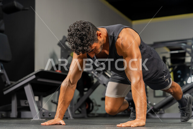 حرق الدهون وتقليل الوزن، إيماءات القوة والنشاط، تقوية الجسم وبنائه، شاب عربي خليجي إماراتي يرتدي ملابس الرياضة يقوم بممارسة التمارين الرياضية البدنية، المحافظة على أسلوب حياة صحي، مفهوم اللياقة والرشاقة، رجل سعودي يمارس أنشطة لتقوية العضلات