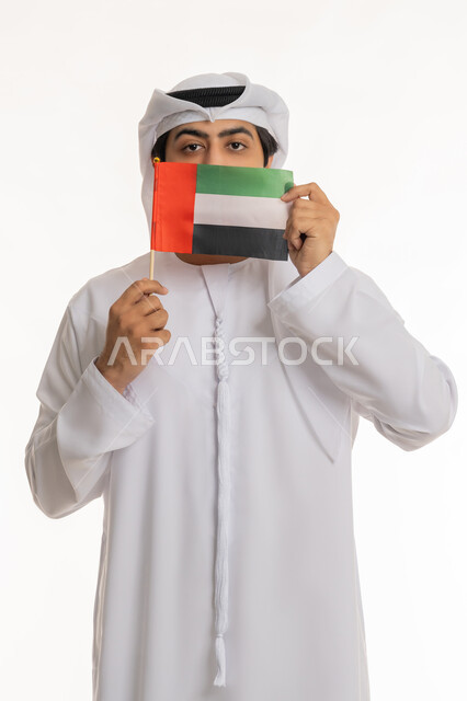 ذكرى اليوم الوطني الإماراتي 2 ديسمبر, الاحتفال بالأعياد والمناسبات الوطنية, مفهوم الحب والفخر بالوطن, تعابير الانتماء والاعتزاز بالهوية الإماراتية, بورتريه لرجل عربي خليجي إماراتي يرتدي الكندورة والغترة البيضاء يحمل علم الإمارات، خلفية بيضاء