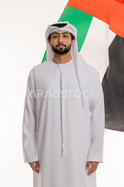 مفهوم الحب والانتماء بالهوية الإماراتية, الاحتفال بالأعياد والمناسبات الوطنية, ذكرى اليوم الوطني الإماراتي 2 ديسمبر, بورتريه لرجل عربي خليجي إماراتي يرتدي الكندورة والغترة البيضاء ينظر إلى الكاميرا بتعابير الفخر والاعتزاز، خلفية بيضاء