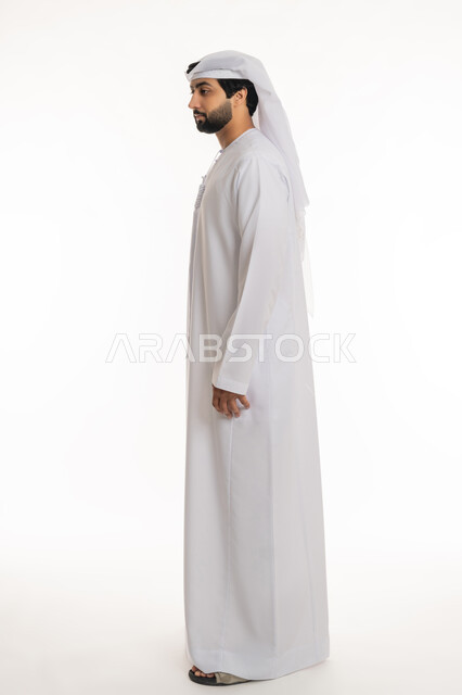 Concern for appearance, concept of masculinity and elegance, side portrait of an Arab Gulf Emirati man wearing a white kandura and ghutra, standing straight and upright, full body, white background
