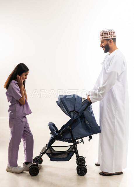 أهمية الأب ودوره الأساسي في تربية ونشأة الأبناء, الرعايه والاهتمام بالأولاد، بورتريه لرجل عربي خليجي عماني يرتدي الدشداسة والكمة يقوم بجرعربة الأطفال مع ابنته, القيام بالنزهات والجولات العائلية، عائلة عمانية تقضي اوقات ممتعة ومسلية، خلفية بيضاء
