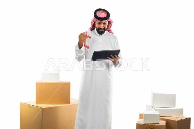 Portrait of a Saudi Arabian Gulf man working in the delivery of orders and goods to customers, online shopping, online orders, reliable shipping and delivery process, warehouse keeper, sales representative, documenting orders, confirming reservations, mak