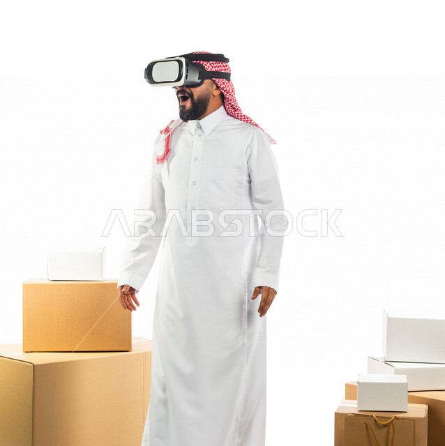 Portrait of a Saudi Arabian Gulf man working in shipping and delivery of orders wearing virtual reality glasses, using modern technology to deliver orders, shipping and delivery in the virtual world, advanced services, express delivery service with modern