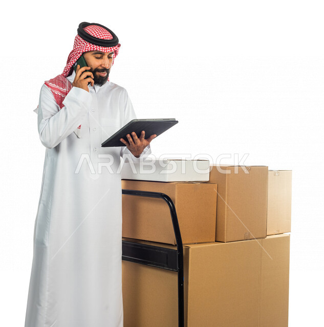 Portrait of a Saudi Arabian Gulf man working in the delivery of orders and goods to customers, online shopping, online orders, store keeper, sales representative, documenting orders, confirming reservations, ensuring the availability and availability of g