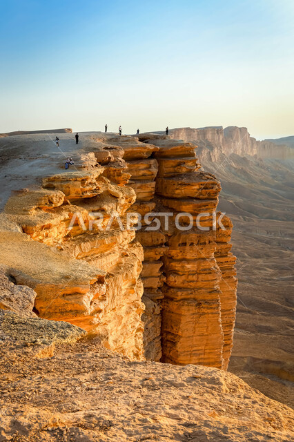 سلسلة جبال طويق في نجد وقت غروب الشمس، الطبيعة الصحراوية والتضاريس الجبلية في السعودية، معالم طبيعية اثرية سياحية مشهورة، حافة نهاية العالم الصخرية في صحراء الرياض في المملكة العربية السعودية