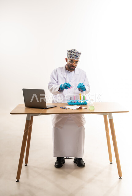 Biochemistry concept, integration of modern devices and technology into practical life, conducting scientific experiments and research, portrait of an Arab Gulf Omani laboratory worker wearing a white coat and gloves using test tubes, white background