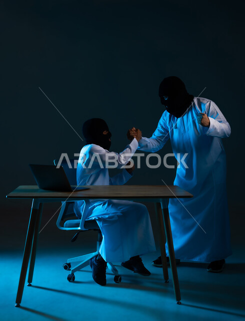 التسلل عبر الأمن السيبراني، قرصنة وسرقة البيانات, خوارزميات لتدمير الحسابات الرقمية, استخدم جهاز الحاسوب لأغراض غير قانونية, بورتريه لهكرين عربيين خليجيين عمانيين ملثمين يرتديان الدشداشة يرفعان قبضة يديهما بتعابير الفرح, خلفية زرقاء