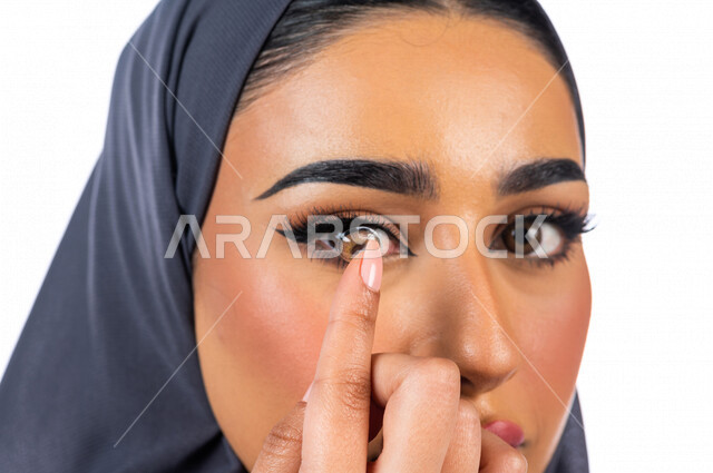 بورتريه بصورة مقربة لمرأة عربية خليجية سعودية تضع العدسات اللاصقة التجميلية في عينها، التسويق للعدسات اللاصقة، متجر بيع العدسات اللاصقة عبر الإنترنت، مفهوم تصحيح  النظر وطب العيون، الرؤية الواضحة، مفهوم العدسات اللاصقة الطبية التجميلية ولتصحيح النظر