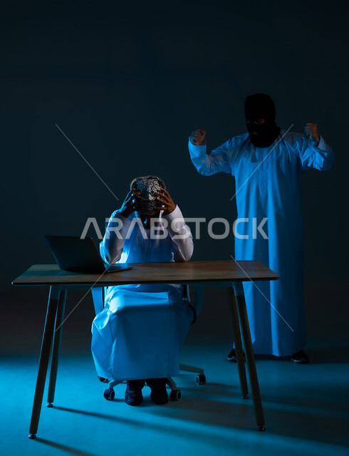 نجاح عملية قرصنة وسرقة البيانات, التعرض للهجمات والاختراقات، اختراق حماية وأمن المستخدمين، مفهوم الجرائم الالكترونية, بورتريه لرجل عربي خليجي عماني يرتدي الدشداشة والكمة يستعمل الحاسوب المحمول يضع يده على رأسه يقف خلفه المخترق, خلفية زرقاء