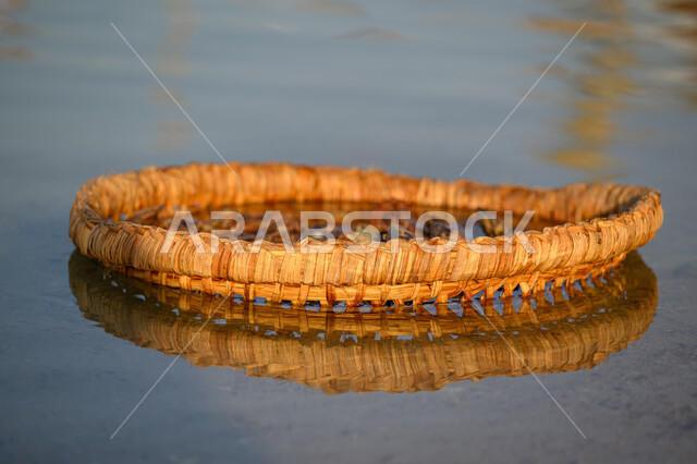 اداة لصيد السمك والكائنات البحريه، قوارب صغيرة فارغة على شكل وعاء، قارب خفيف الوزن مصنوعة من القصب المنسوج المقاوم للماء، مهرجان كتارا الرابع عشر للمحامل، الواجهة البحرية في دولة قطر في النهار، أماكن سياحية لقضاء أوقات ممتعة، الاستمتاع بالرحلات البحرية الهادئة