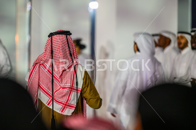 الأعياد والمناسبات الوطنية, الاحتفال باليوم الوطني لدولة قطر 18 ديسمبر, مفهوم الحب والانتماء للبلاد, صورة من الخلف لرجل عربي خليجي قطري يرتدي الثوب التقليدي والشماغ يقف في إحدى فعاليات الدوحة