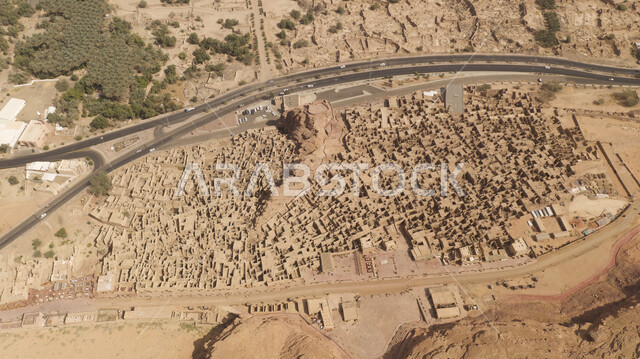 Mountain peaks and heights, ancient historical landmarks and areas, paved asphalt road between mud houses and heritage homes, historical buildings in the old town in Al-Ula Governorate in the Kingdom of Saudi Arabia, rock formations and formations in tourist places