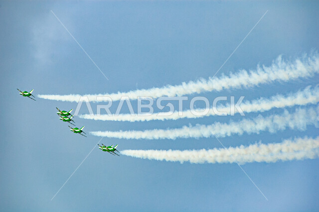 إحياء ذكرى اليوم الوطني السعودي 23 سبتمبر، عرض جوي للاحتفال باليوم الوطني، التعبير عن الحب والولاء للبلاد في الأعياد والمناسبات الوطنية، خطوط من الدخان خلف الطائرات النفاثة المحلقة في سماء المملكة العربية السعودية، خلفية  السماء الزرقاء