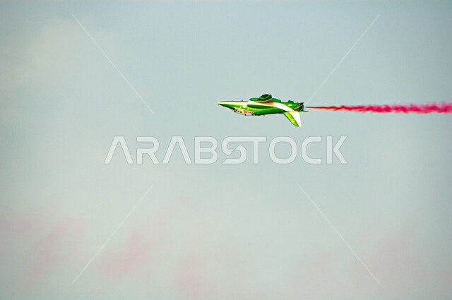 خط  دخان باللون الأحمر خلف طائرة نفاثة المحلقة في سماء المملكة العربية السعودية، التعبير عن الحب والولاء للبلاد في الأعياد والمناسبات الوطنية، إحياء ذكرى اليوم الوطني السعودي 23 سبتمبر، خلفية  السماء الزرقاء