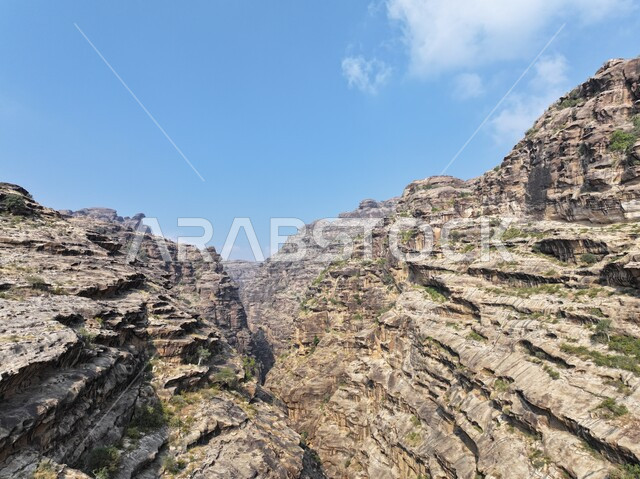 Famous tourist places and landmarks in the Kingdom of Saudi Arabia, highlands and mountain ranges, rock formations and formations in the city of Jazan, green plants planted on the mountains of Al-Qahr, distinctive natural landscapes