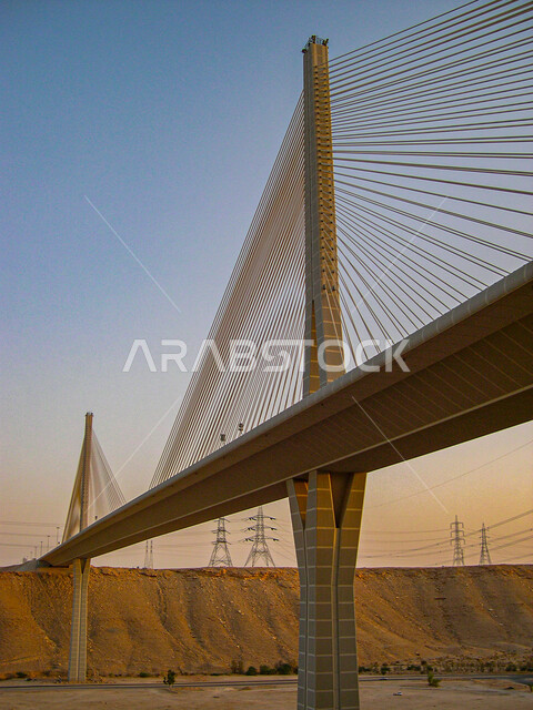 الفن الهندسي المعماري المتطور للبنية التحتية في العاصمة، الجسر المعلق المدعم بالكوابل المطل على وادي لبن في مدينة الرياض في النهار، المعالم السياحية المشهورة في المملكة العربية السعودية