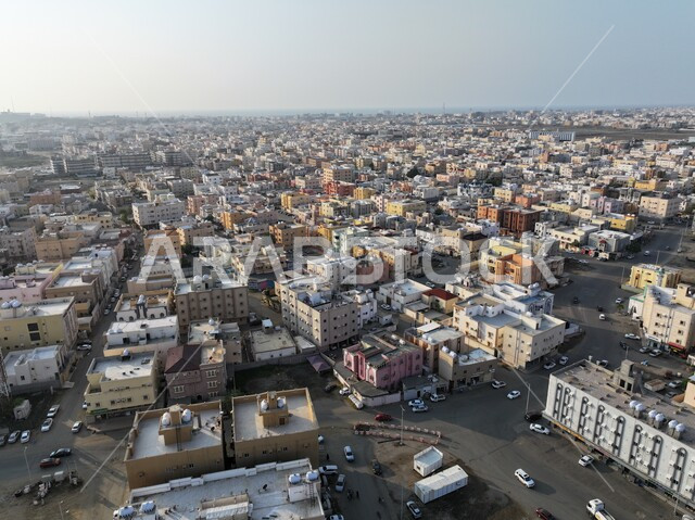 مفهوم تطوير وتحسين البنية التحتية، البيوت والمباني السكنية في مدينة جازان، النمو والتطور العمراني في المملكة العربية السعودية، صورة من الأعلى للمنشآت والمؤسسات التجارية، حركة المرور والسيارات في الطرقات والشوارع