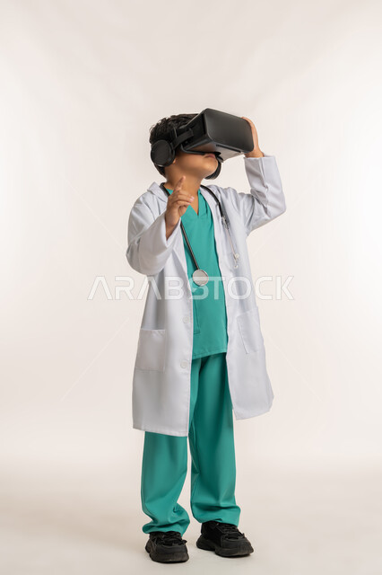 دمج  الطب والرعاية الصحية مع الواقع الافتراضي، تحديد موقع شيء معين، بورتريه لفتى عربي خليجي اماراتي يرتدي المعطف الأبيض يضع نظارة الفي ار ويقوم بالتفاعل مع العالم الخيالي، ولد سعودي يشير باصبع السبابة إلى مكان ما، الجسم بالطول الكامل، خلفية بيضاء