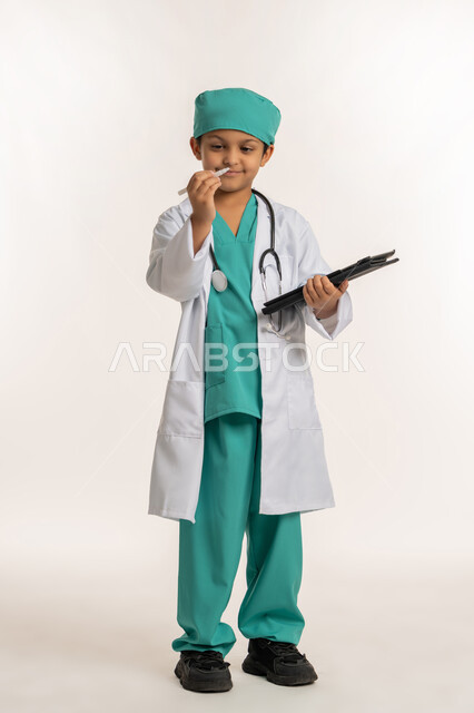 تسجيل نتائج الفحوصات، الأهداف والطموحات المستقبلية بالعمل في العيادات والمشافي، تحديد مهنة المستقبل، بورتريه لصبي عربي خليجي اماراتي يرتدي المعطف الأبيض والسماعات يحمل بيده جهاز التابلت، ولد سعودي بقوم بإعداد التقارير الطبيه، صورة لكامل الجسم، خلفية بيضاء