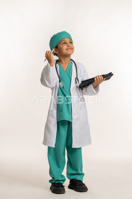 تدوين نتائج الفحوصات، الأهداف والطموحات المستقبلية بالعمل في العيادات والمشافي، تحديد مهنة المستقبل، بورتريه لصبي عربي خليجي اماراتي يرتدي المعطف الأبيض والسماعات يحمل بيده جهاز التابلت، ولد سعودي بقوم بإعداد التقارير الطبيه، صورة لكامل الجسم، خلفية بيضاء