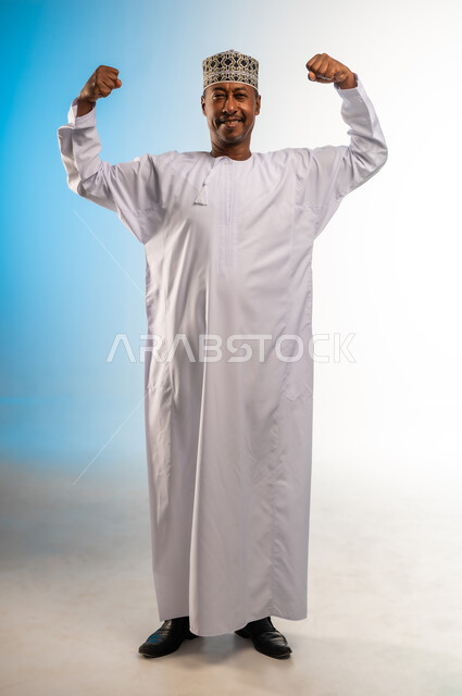 Interest in physical fitness, regular exercise, healthy diet, building muscle mass, concept of strength and masculinity, portrait of a smiling Omani Gulf Arab man wearing a dishdasha and a thobe looking at the camera with gestures of happiness, full body, colorful background